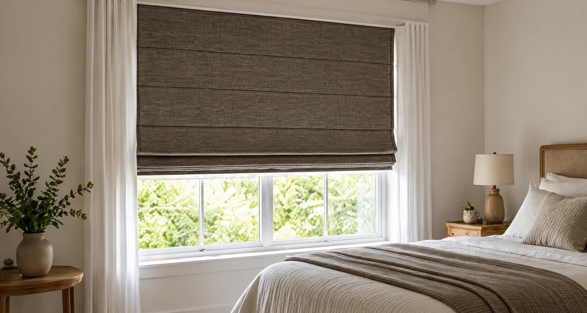Dark textured Roman shade above a bedroom window beside a neutral bed